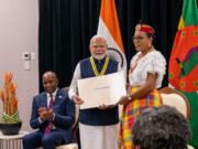 Dominica’s Prime Minister has told India’s Prime Minister that the world owes him a debt of gratitude
