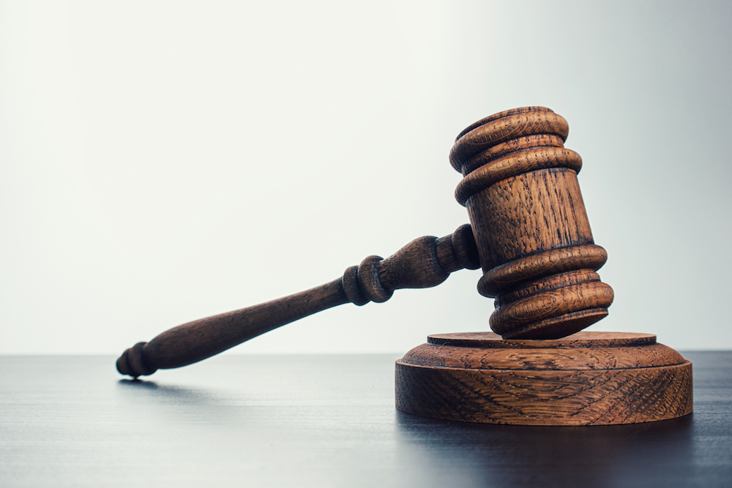 Close-Up Of Wooden Hammer And Gavel On Table Against Gray Background